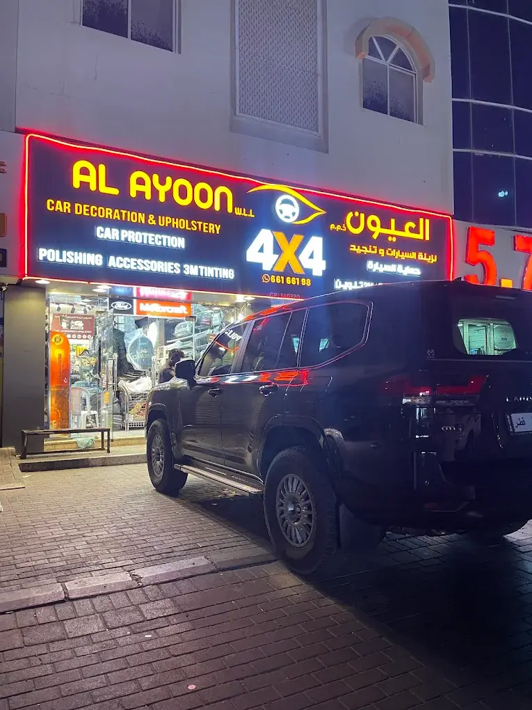 Al Ayoon 4x4 Car Decoration & Upholstery illuminated storefront at night with a Land Cruiser parked outside, Al Wakrah, Qatar